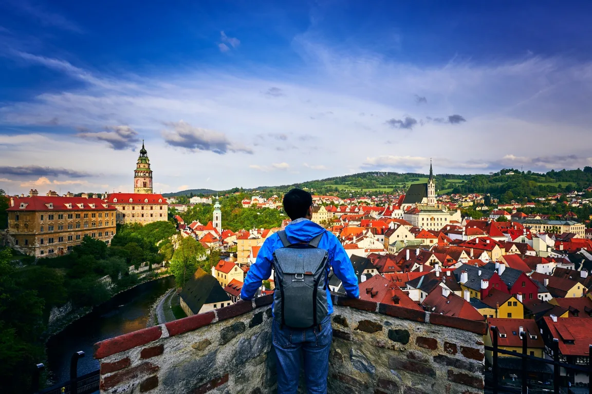 Traveller overlooking a vibrant European city skyline at sunset, evoking a relaxed and energetic city break mood.
